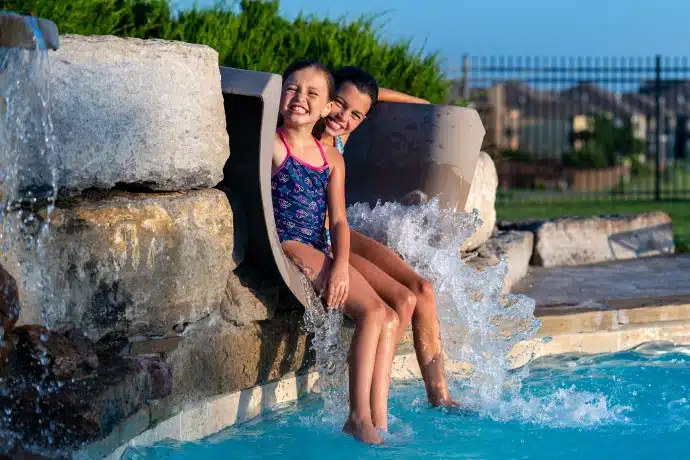 two girls playing on the pool slide