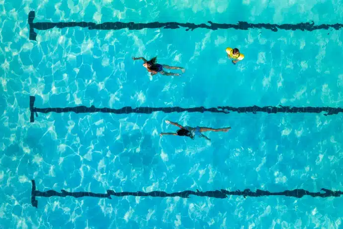 kids swimming in the lanes in the swimming people - aerial view
