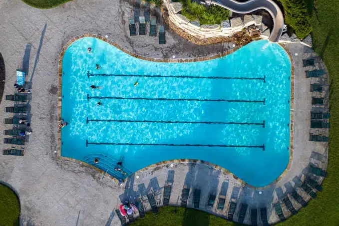 community pool aerial view with lanes and peole swimming in the pool
