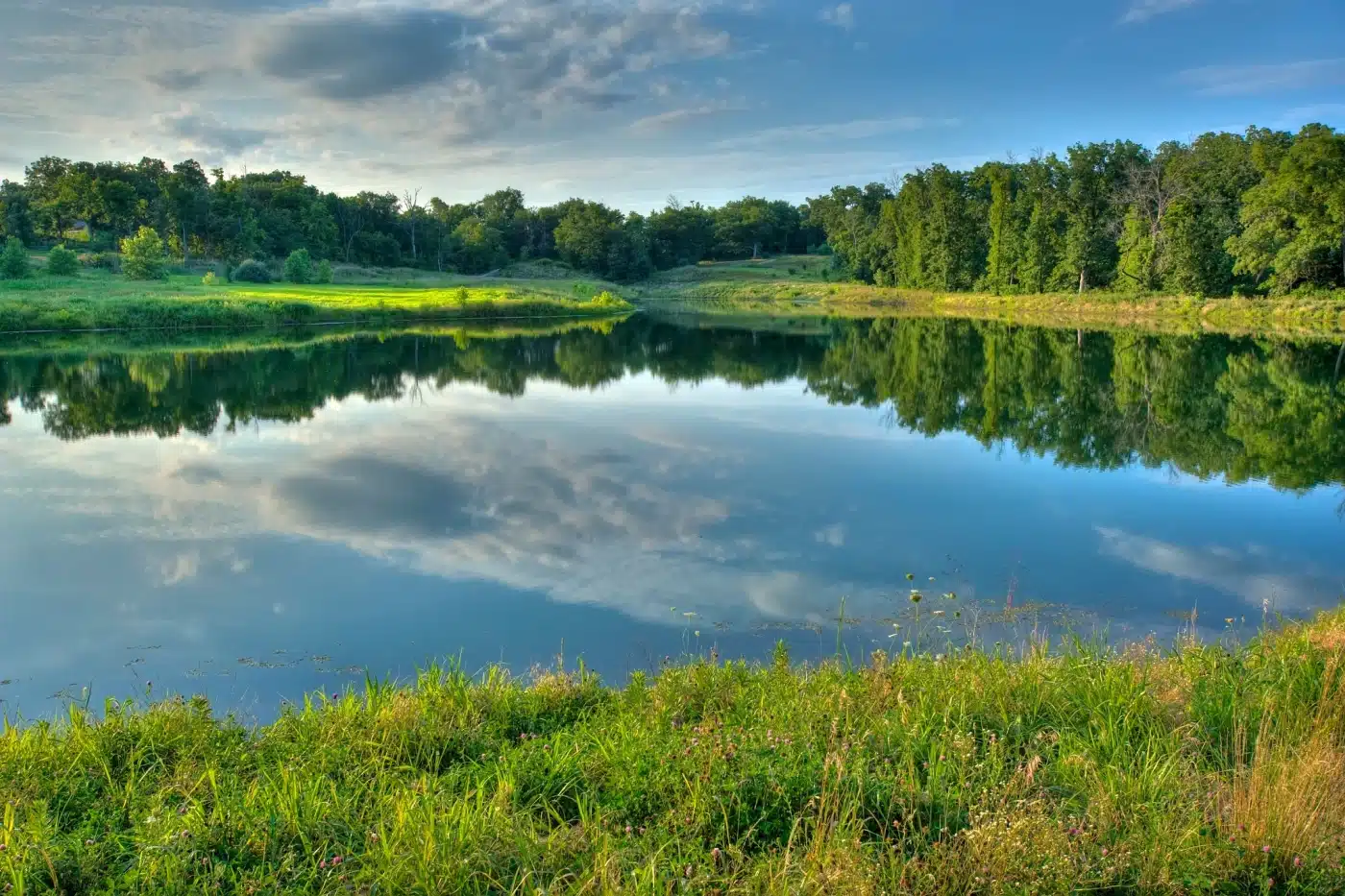 view of the commuinty lake with the sky reflecting in the water